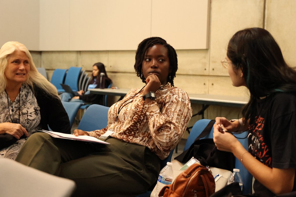 Three people from diverse backgrounds talking.