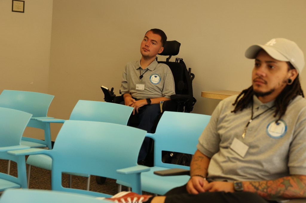 Two men sitting in a well-lit room, engaged in a discussion or meeting.
